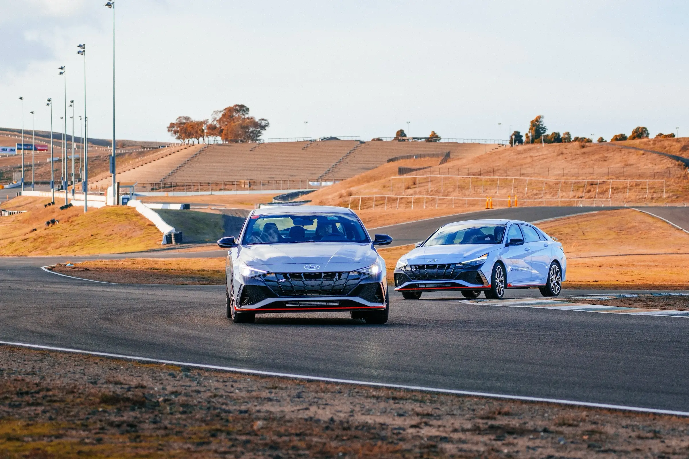 zwei Hyundai Elantra N fahren durch eine kurvenreiche Sektion der Rennstrecke.