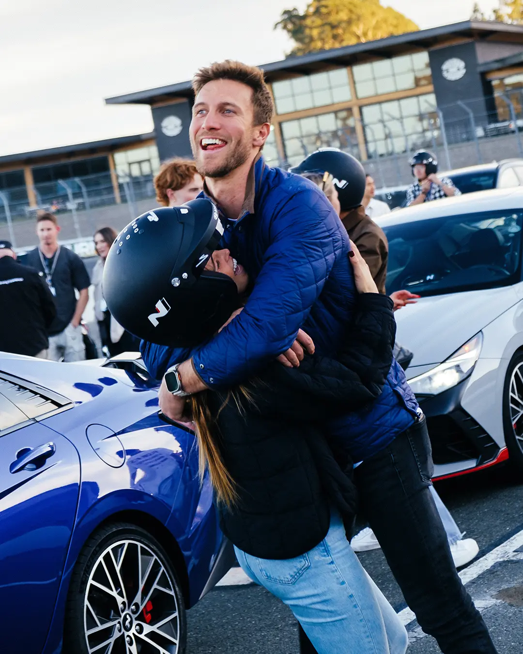 Ein teilnehmendes Paar umarmt und freut sich nach der Teilnahme an der Driving Experience.